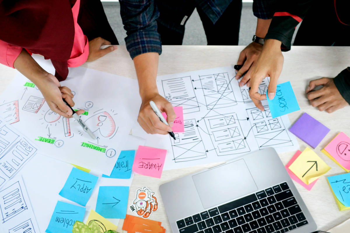 Team plant mit Haftnotizen, Skizzen und Wireframes den Weg der Besucher durch eine Website