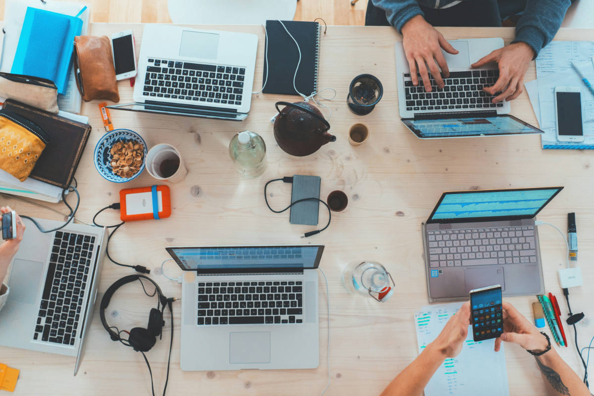 Laptops, Tablets und Smartphones nebeneinander auf einem Tisch – dieselbe Website auf verschiedenen Bildschirmgrössen
