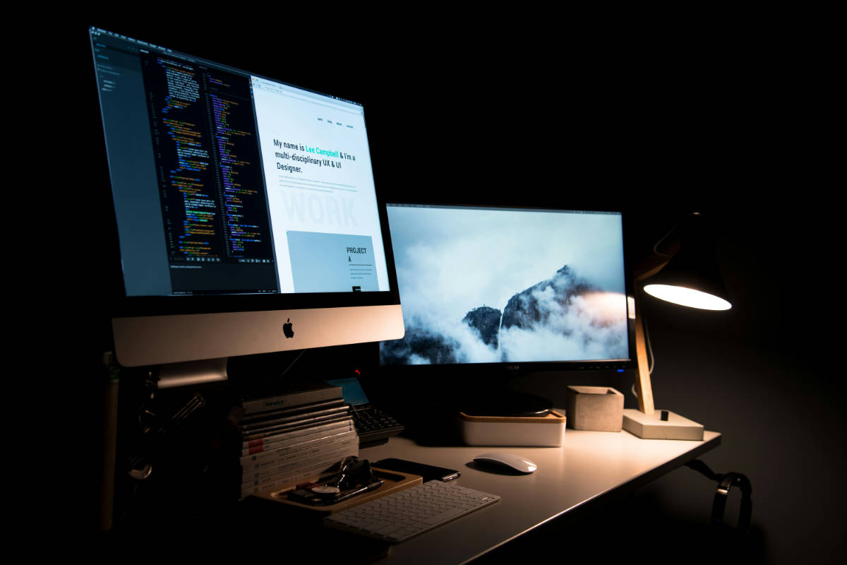 Abgedunkelter Arbeitsplatz, auf dem Bildschirm eine persönliche Portfolio-Website